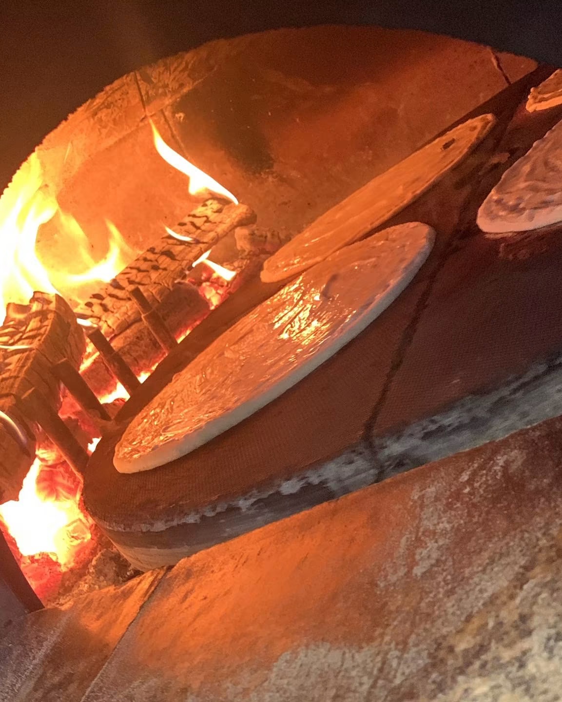 Préparation des pizzas devant le four à bois de BD Pizzas Nercillac