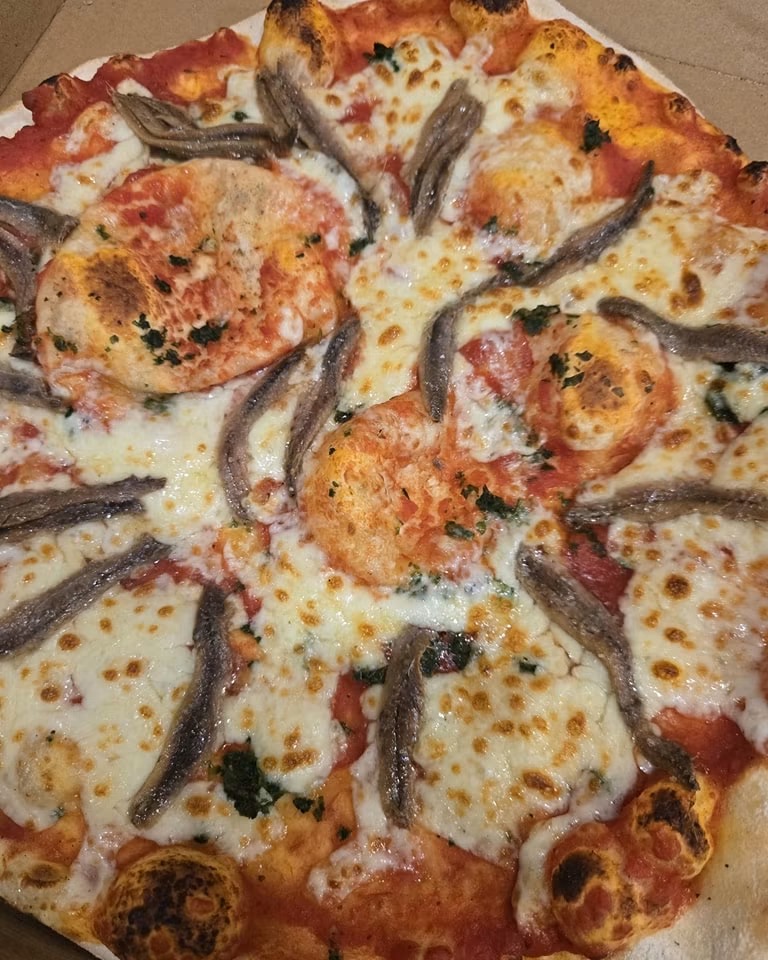 Pizza aux anchois cuite au feu de bois
